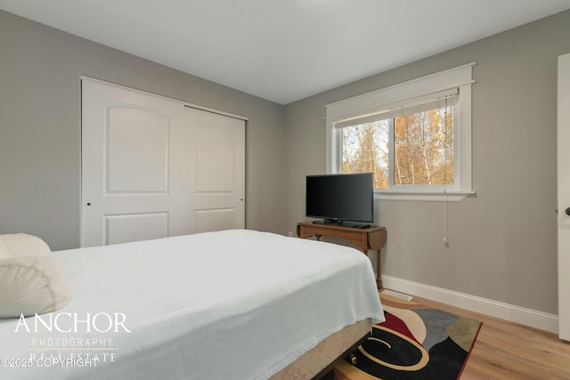 bedroom featuring baseboards, a closet, and wood finished floors