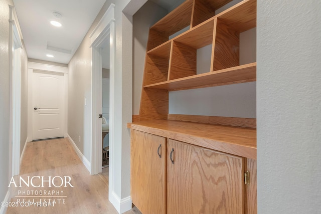 hallway featuring baseboards and light wood-type flooring