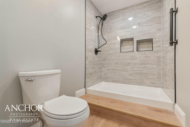 full bathroom featuring toilet and a tile shower