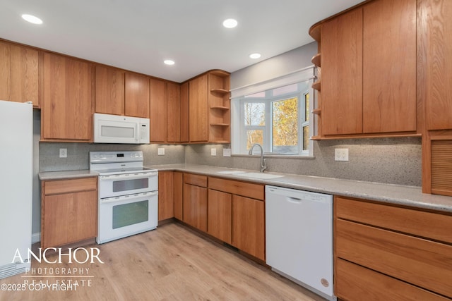 kitchen featuring a sink, open shelves, light wood finished floors, tasteful backsplash, and white appliances
