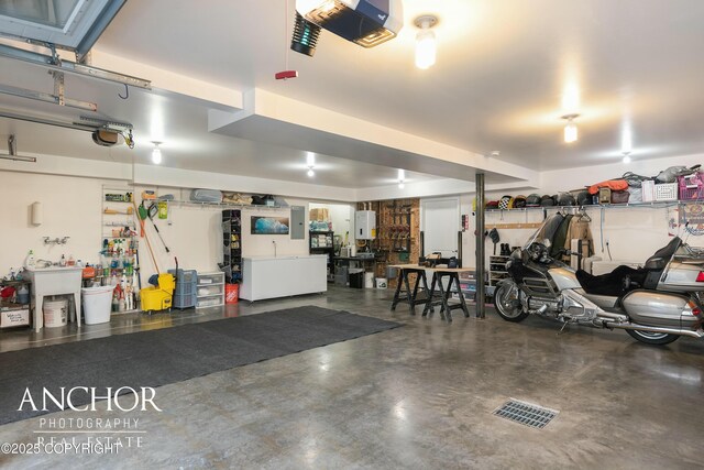 garage featuring water heater, a garage door opener, and a workshop area
