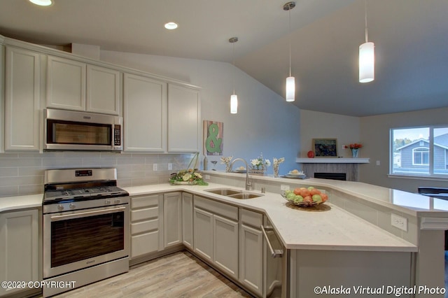 300 Shageluk St, Anchorage, AK 99504 - kitchen with a peninsula, stainless steel appliances, a sink, vaulted ceiling, and backsplash