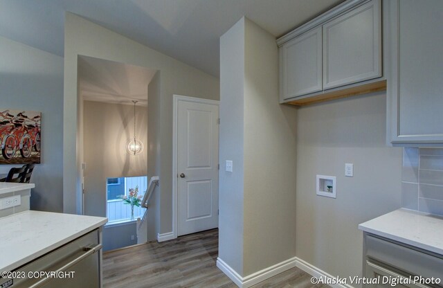 300 Shageluk St, Anchorage, AK 99504 - laundry area with light wood-style flooring, cabinet space, baseboards, and washer hookup