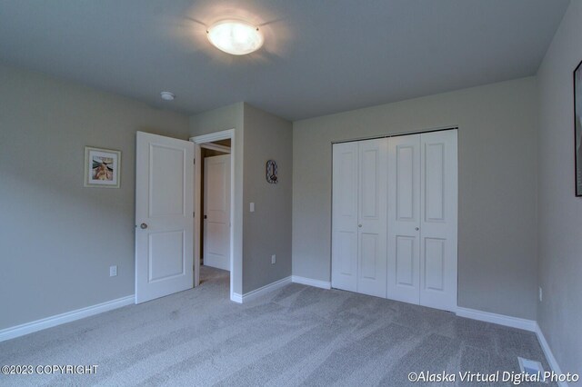 300 Shageluk St, Anchorage, AK 99504 - unfurnished bedroom featuring baseboards, carpet flooring, and a closet