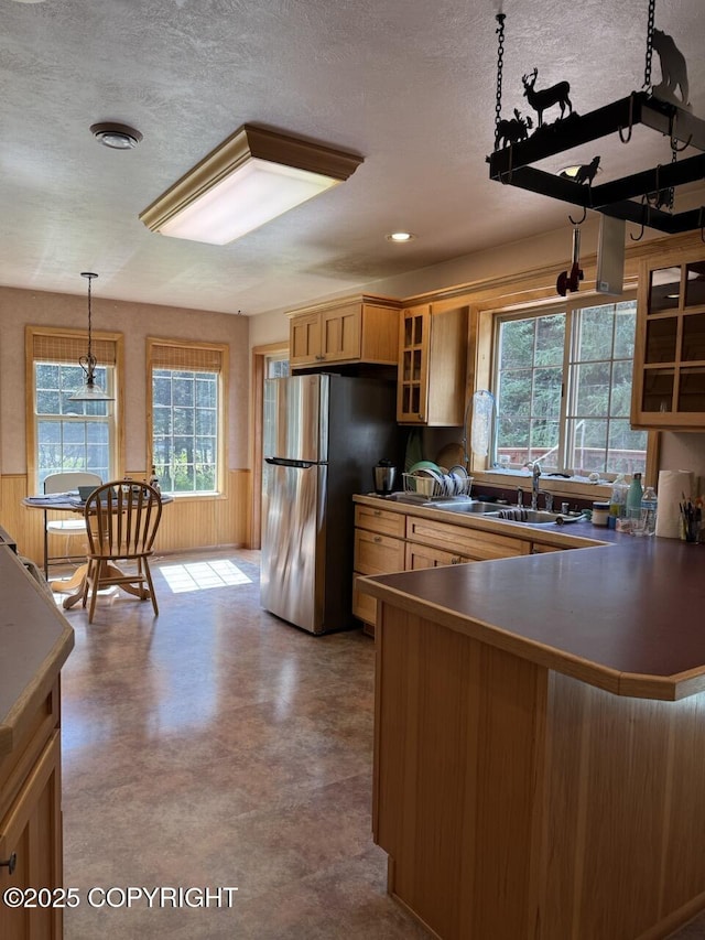 32945 Melanie Ln, Seward, AK 99664 - kitchen with freestanding refrigerator, glass insert cabinets, a wainscoted wall, hanging light fixtures, and dark countertops