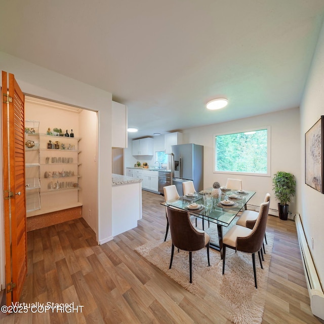 7621 E 4th Ave, Anchorage, AK 99504 - dining space with baseboards, light wood finished floors, and baseboard heating