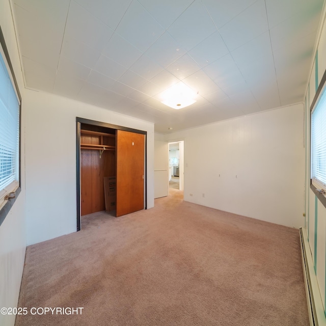 7621 E 4th Ave, Anchorage, AK 99504 - unfurnished bedroom with light carpet, baseboard heating, and a closet