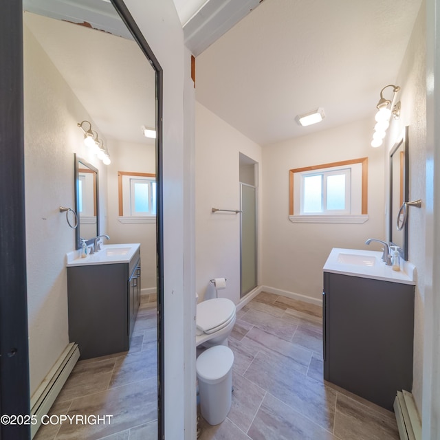 7621 E 4th Ave, Anchorage, AK 99504 - full bathroom with toilet, a baseboard heating unit, a sink, and two vanities