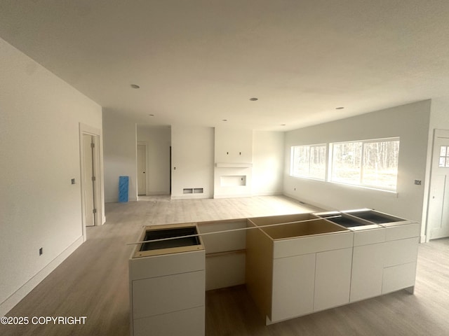 kitchen with visible vents, white cabinetry, wood finished floors, and modern cabinets