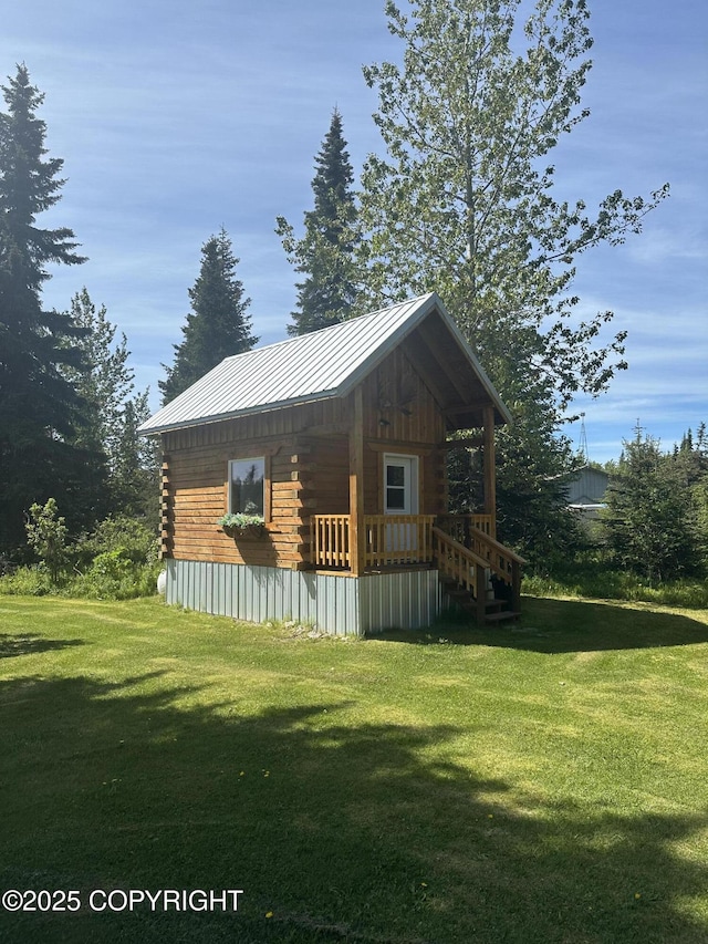 34581 N Fork Rd, Anchor Point, AK 99556 - view of front of home featuring log exterior, a front yard, a standing seam roof, a metal roof, and an outbuilding