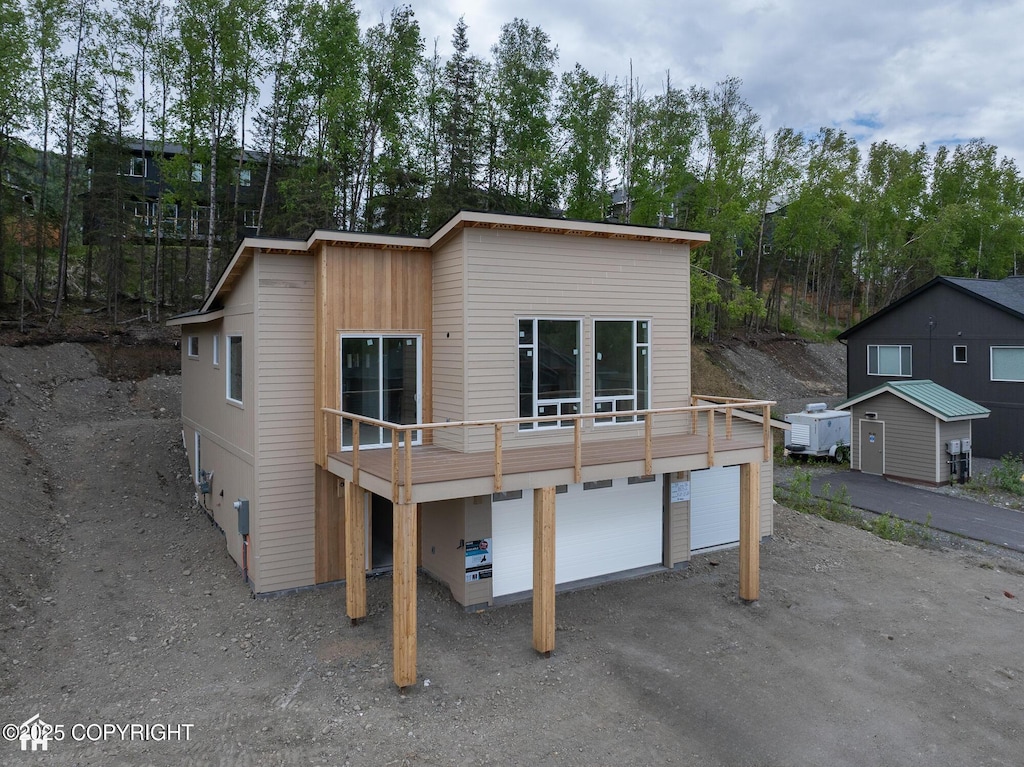 18052 Rivervista Rd, Eagle River, AK 99577 - view of front facade featuring driveway, an attached garage, and view of scattered trees