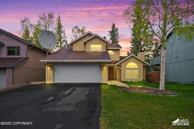traditional-style house with asphalt driveway, roof with shingles, and an attached garage