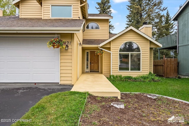 traditional-style house featuring a shingled roof and driveway