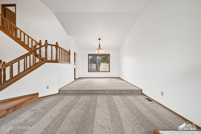 unfurnished living room with vaulted ceiling, carpet, a chandelier, stairway, and baseboards