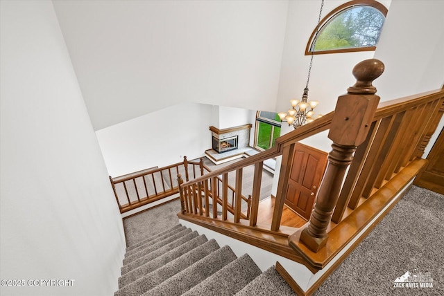 stairs with carpet and a chandelier
