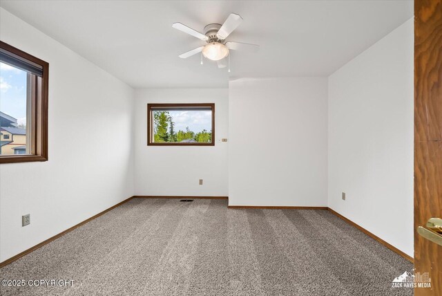 empty room featuring carpet floors, baseboards, and ceiling fan