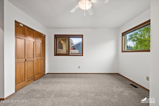 unfurnished bedroom with carpet, a closet, and baseboards