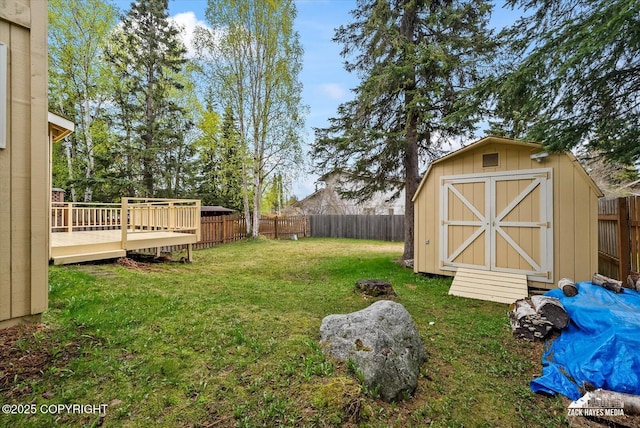view of yard featuring a storage shed, a deck, and an outdoor structure