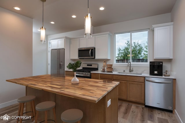3680 Little Bear Pl # 8, Anchorage, AK 99504 - kitchen featuring appliances with stainless steel finishes, a sink, wooden counters, light wood-style floors, and recessed lighting