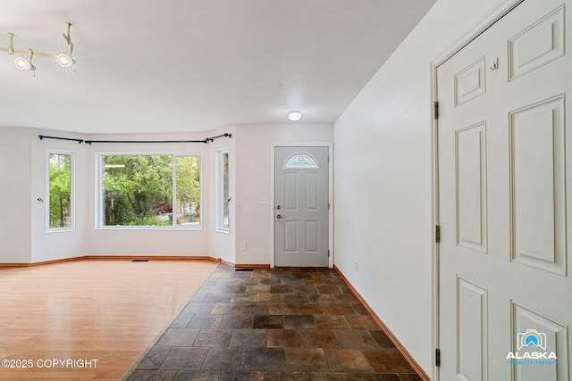 19306 Second St, Eagle River, AK 99577 - foyer featuring baseboards, dark stone finish floors, and track lighting