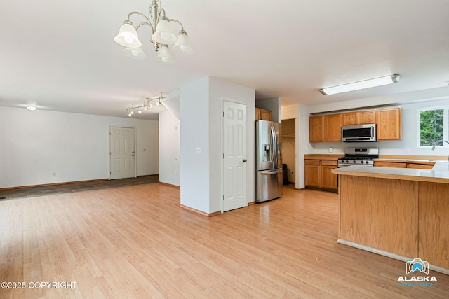 19306 Second St, Eagle River, AK 99577 - kitchen with stainless steel appliances, light wood-style flooring, open floor plan, and brown cabinetry