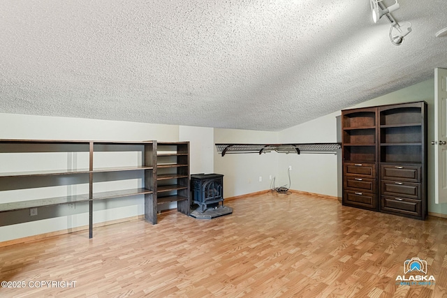 19306 Second St, Eagle River, AK 99577 - walk in closet featuring a wood stove, wood finished floors, and vaulted ceiling
