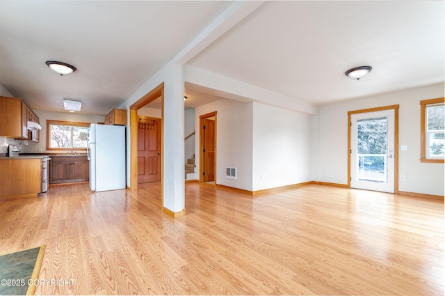 5751 N Tongass Hwy, Ketchikan, AK 99901 - unfurnished living room with light wood-style flooring, baseboards, stairs, and visible vents