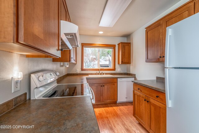 5751 N Tongass Hwy, Ketchikan, AK 99901 - kitchen featuring white appliances, a sink, dark countertops, light wood-style flooring, and brown cabinetry