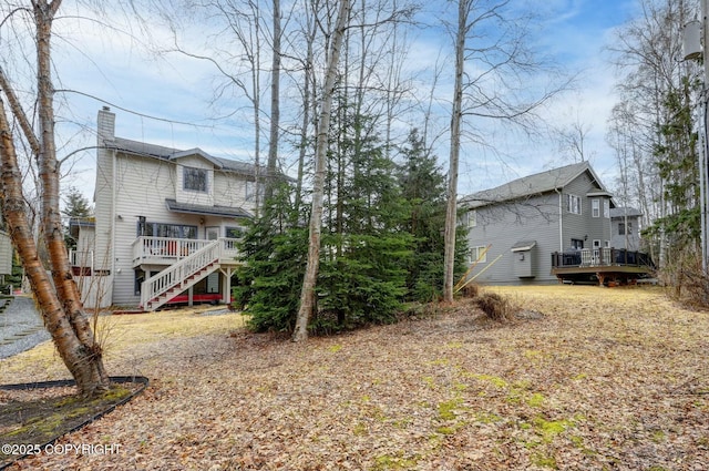 exterior space with a chimney, a deck, and stairs