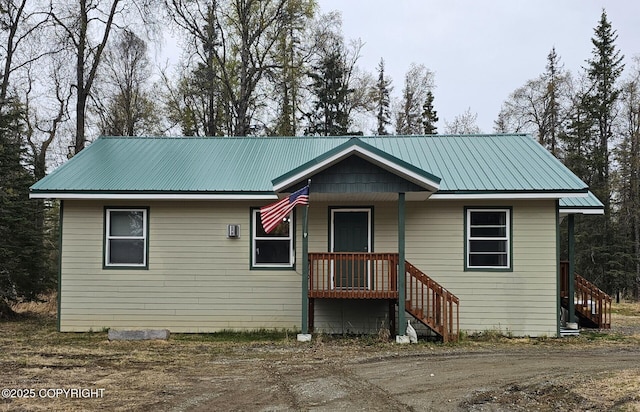 view of front of property featuring metal roof and stairs