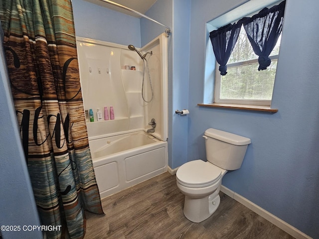 bathroom with wood finished floors, baseboards, toilet, and shower / bath combination with curtain