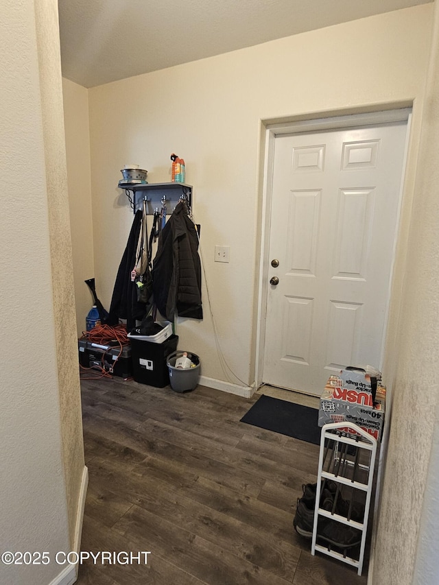 mudroom featuring dark wood finished floors and baseboards