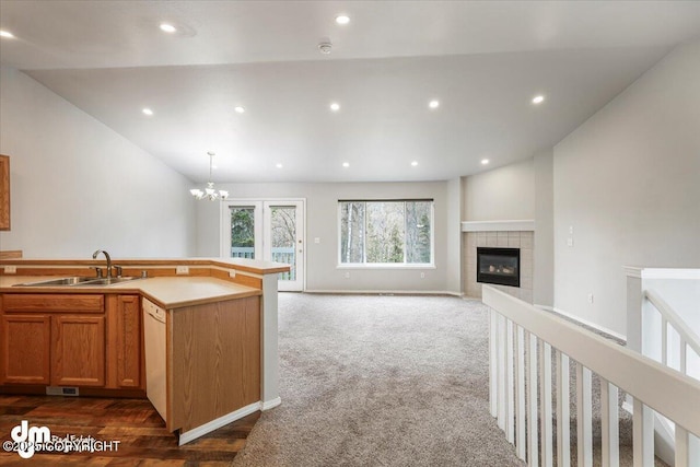 kitchen featuring a notable chandelier, a sink, a fireplace, dishwasher, and recessed lighting