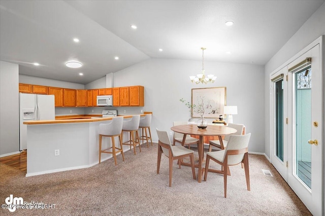 dining area with a notable chandelier, light carpet, visible vents, baseboards, and vaulted ceiling