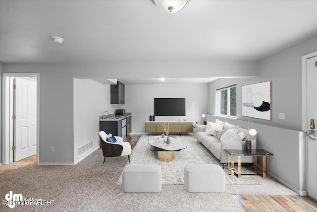 living room featuring visible vents, baseboards, and light colored carpet