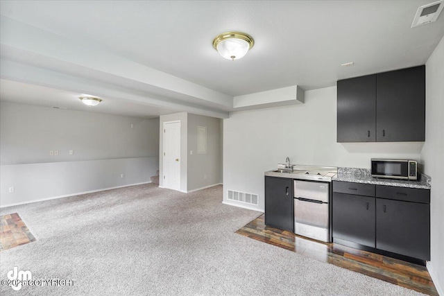 kitchen with appliances with stainless steel finishes, baseboards, carpet floors, and visible vents