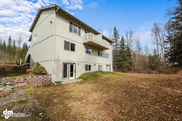 back of property featuring a yard and a balcony
