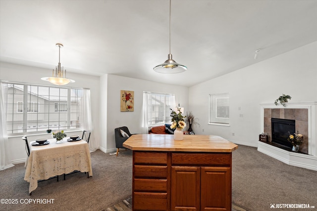 kitchen with dark carpet, a fireplace, vaulted ceiling, and butcher block counters