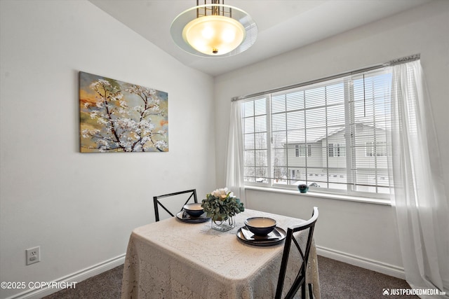 dining room with baseboards, dark carpet, and lofted ceiling