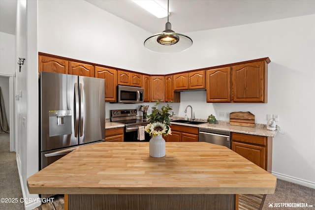 kitchen featuring a towering ceiling, wood counters, appliances with stainless steel finishes, carpet, and a sink