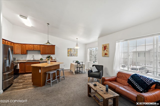living room featuring dark carpet, baseboards, and vaulted ceiling