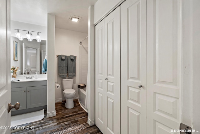 full bath featuring  shower combination, vanity, toilet, and wood finished floors