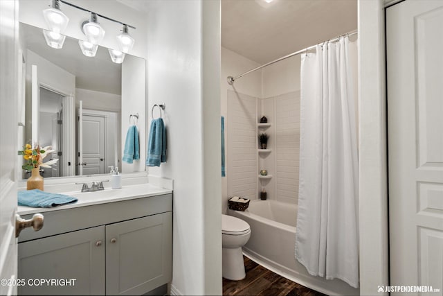 full bath featuring toilet, wood finished floors, vanity, and shower / bath combo with shower curtain