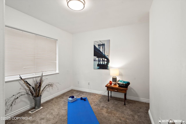 exercise room with visible vents, baseboards, and carpet flooring