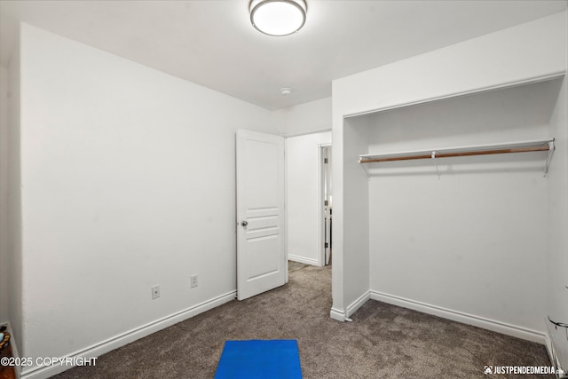 unfurnished bedroom featuring a closet, carpet flooring, and baseboards