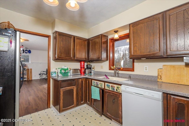 16500 E Smith Rd, Palmer, AK 99645 - kitchen with white dishwasher, light floors, freestanding refrigerator, and a sink