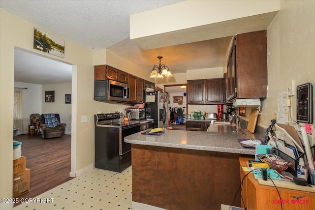 16500 E Smith Rd, Palmer, AK 99645 - kitchen with black electric range, a sink, stainless steel microwave, a peninsula, and a notable chandelier