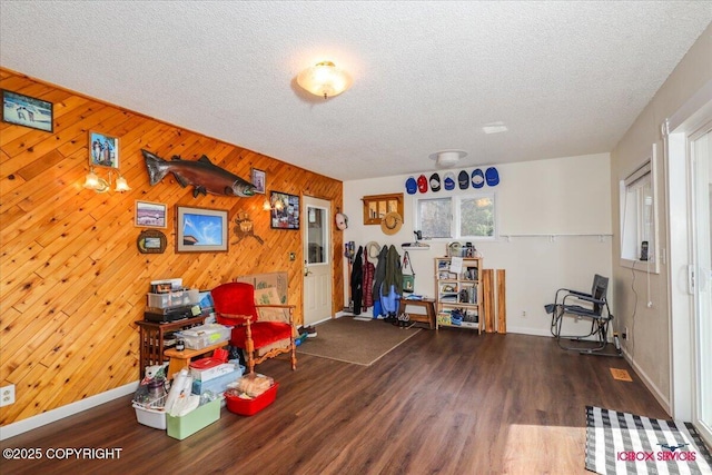 16500 E Smith Rd, Palmer, AK 99645 - miscellaneous room with baseboards, a textured ceiling, wood walls, and wood finished floors