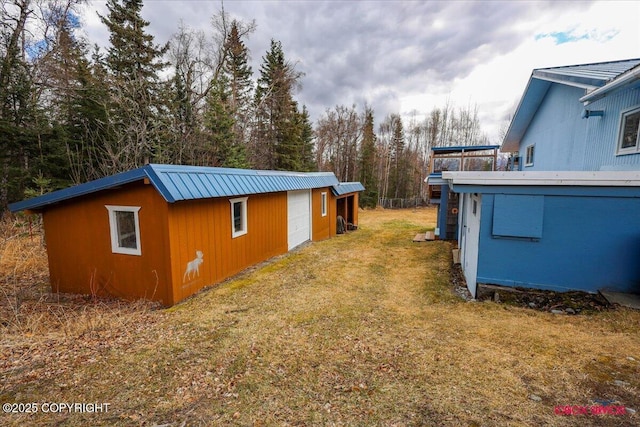 16500 E Smith Rd, Palmer, AK 99645 - view of side of property featuring a lawn, an outbuilding, metal roof, and a detached garage