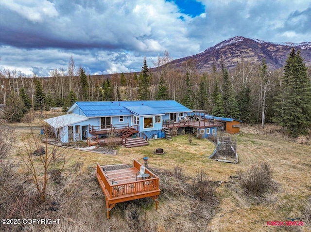 16500 E Smith Rd, Palmer, AK 99645 - back of property with a lawn, a deck with mountain view, metal roof, and a forest view